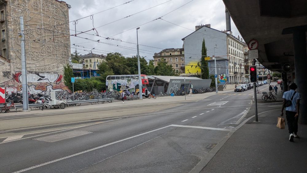 Open air and secure bike store next to the station. Tram tracks in the foreground.