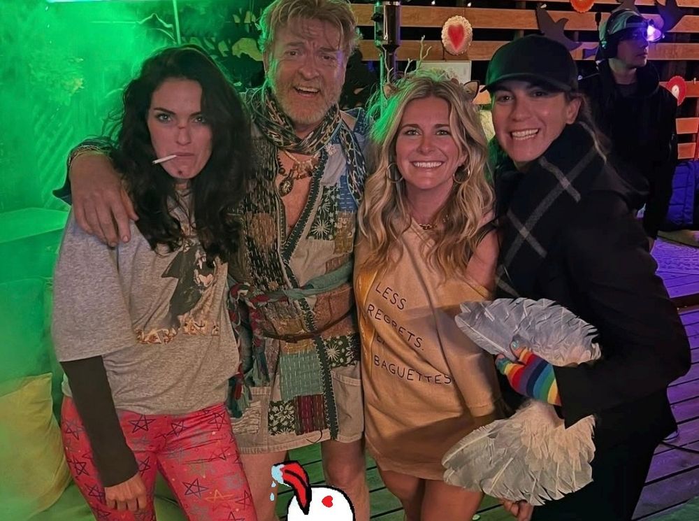 A photo of Rhys in a short robe. A photoshopped cartoon licks his leg.