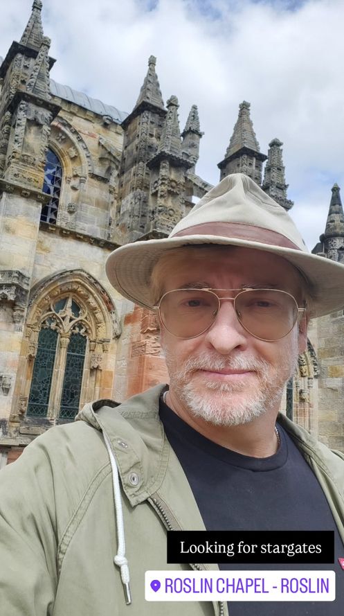 Selfie of Rhys in a beige hat with a cathedral in the background