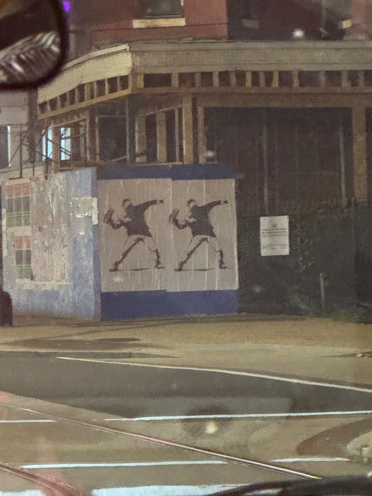 Banksy throwing dude with a sub sandwich on a street corner