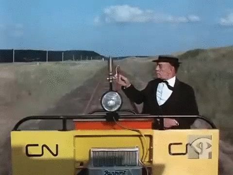 Buster Keaton in The Railrodder, "narrowly dodging" a large locomotive as he travels on a small rail maintenance vehicle in the 1965 short film for NFB Canada. 