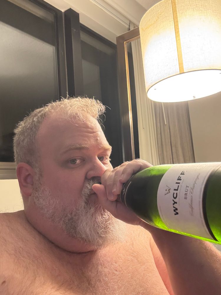 A selfie of me chugging from a bottle of sparkling wine