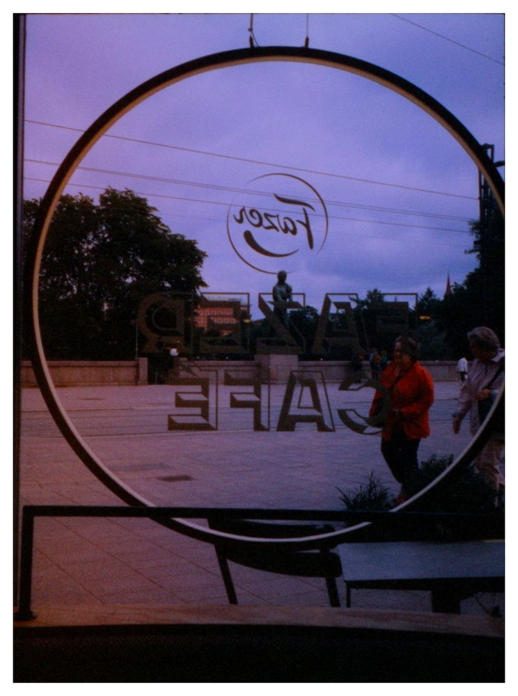 People walking along the Häme bridge, past the Fazer Café.