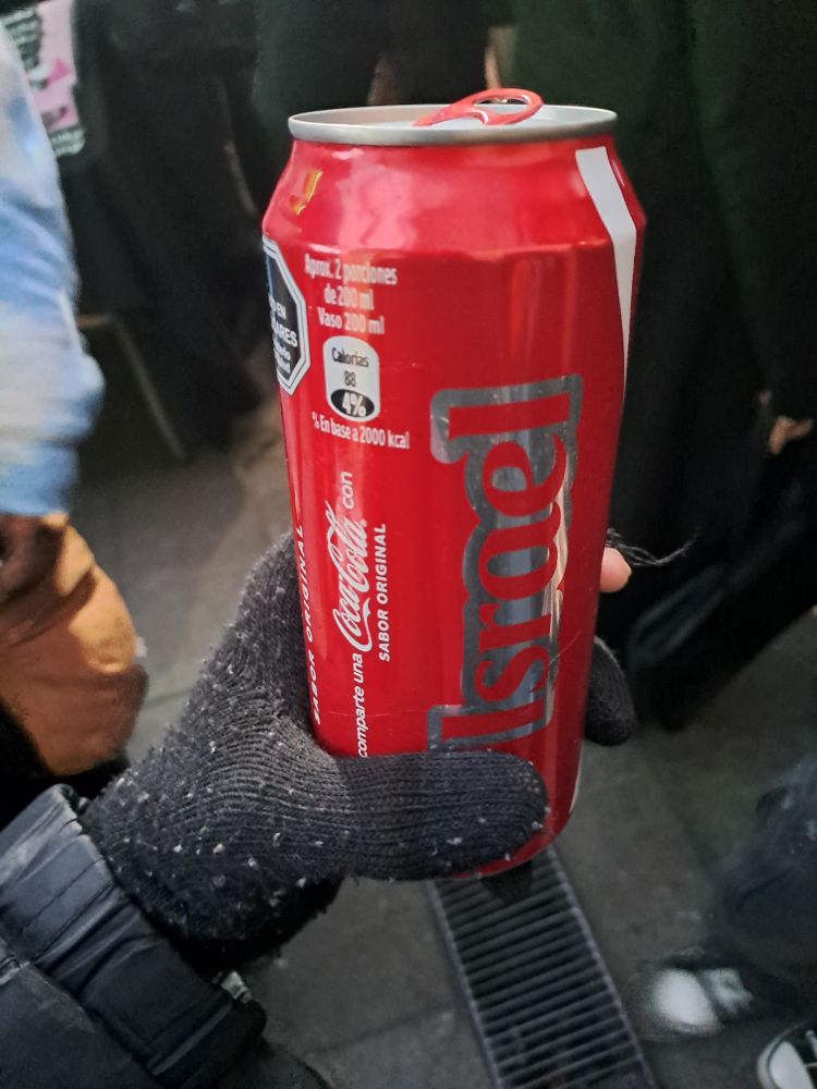 A half-liter can of Coke, with branding printed on it saying "Comparte una Coca-Cola con Israel". This translates to "Share a Coca-Cola with Israel".