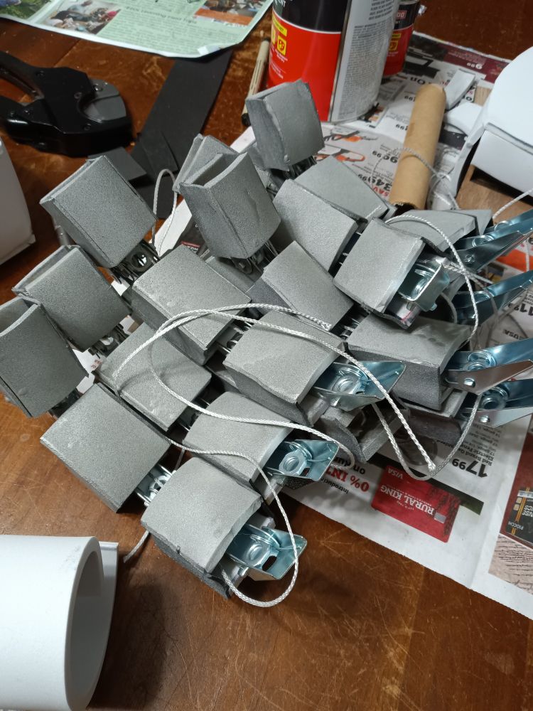 A pile of fingers for a cosplay. The fingers are made of three silver segments made of foam and connected to each other with silver toggle bolts. They look robotic in nature.