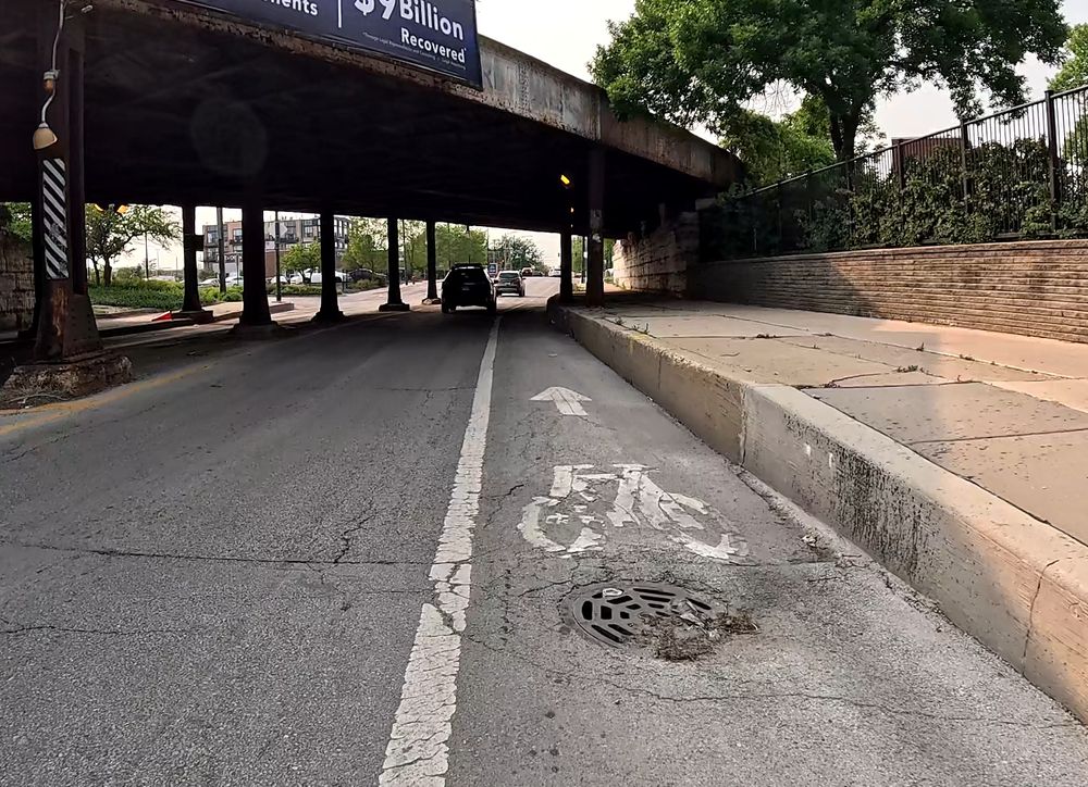 Image of a sewer drain in the middle of the bike path on Clybourn heading northwest. 