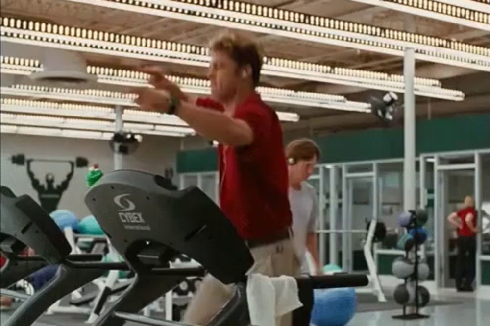 a man is running on a treadmill in a gym that says cybex on it