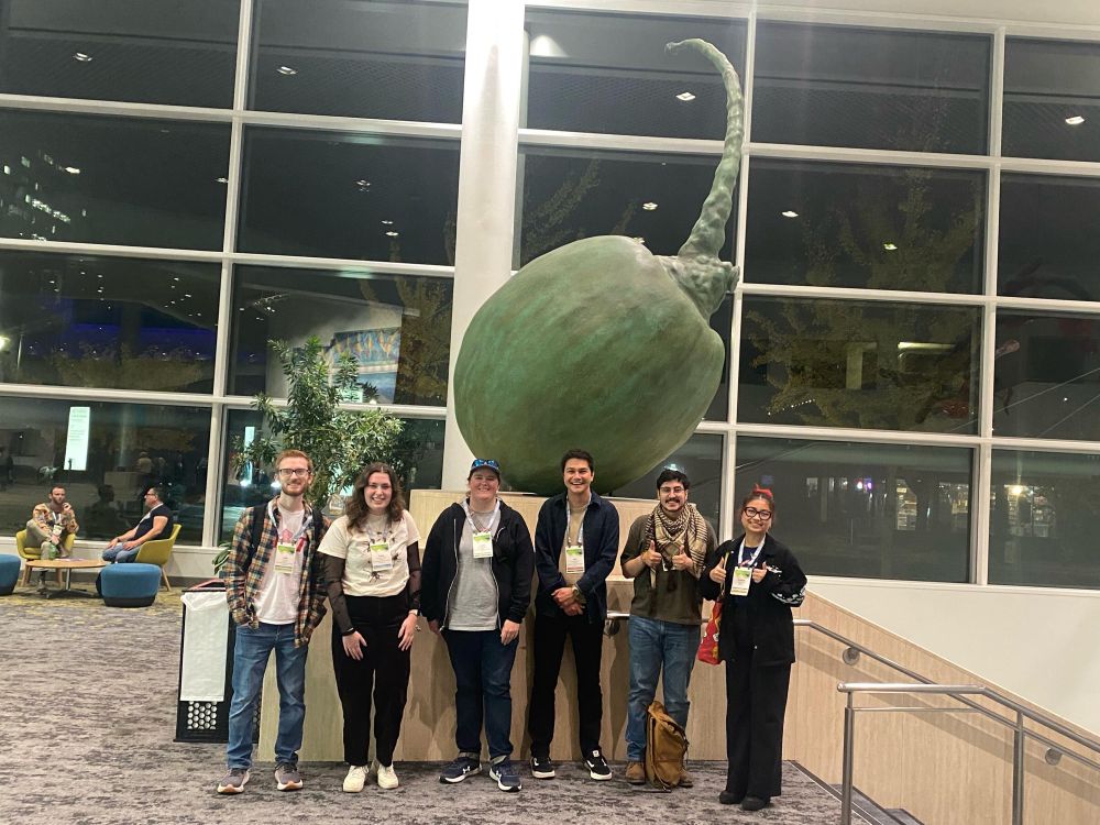 Group of people in the barden lab standing in front of a large ginkoberry statue