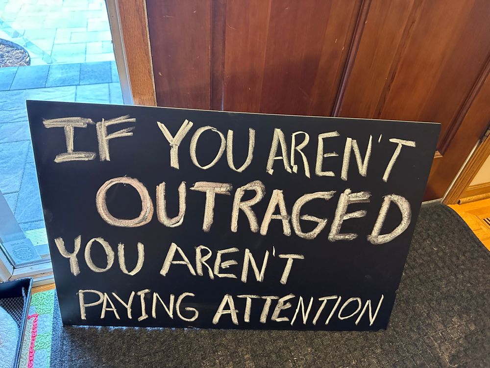 If you aren’t outraged you aren’t paying attention sign 
