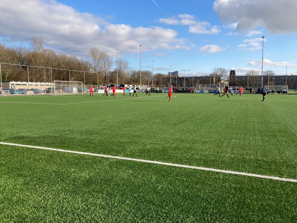 Een foto van de wedstrijd. In de verte staat een gebouwtje waarin de kantine is gevestigd.