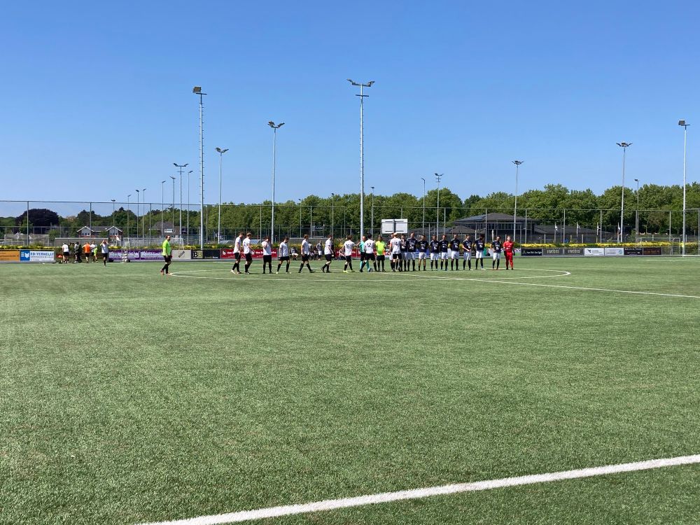 Beide teams geven elkaar een hand.