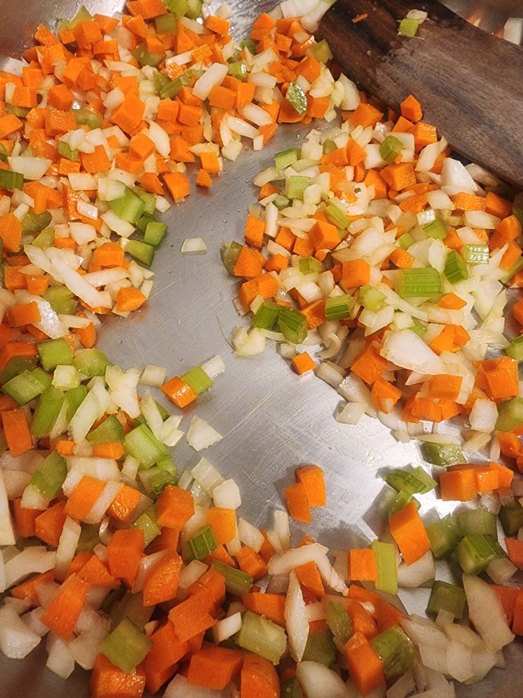 Diced onions, carrots, and celery in a pan.