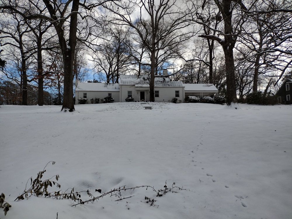 Pretty house with white lawn covered in snow.