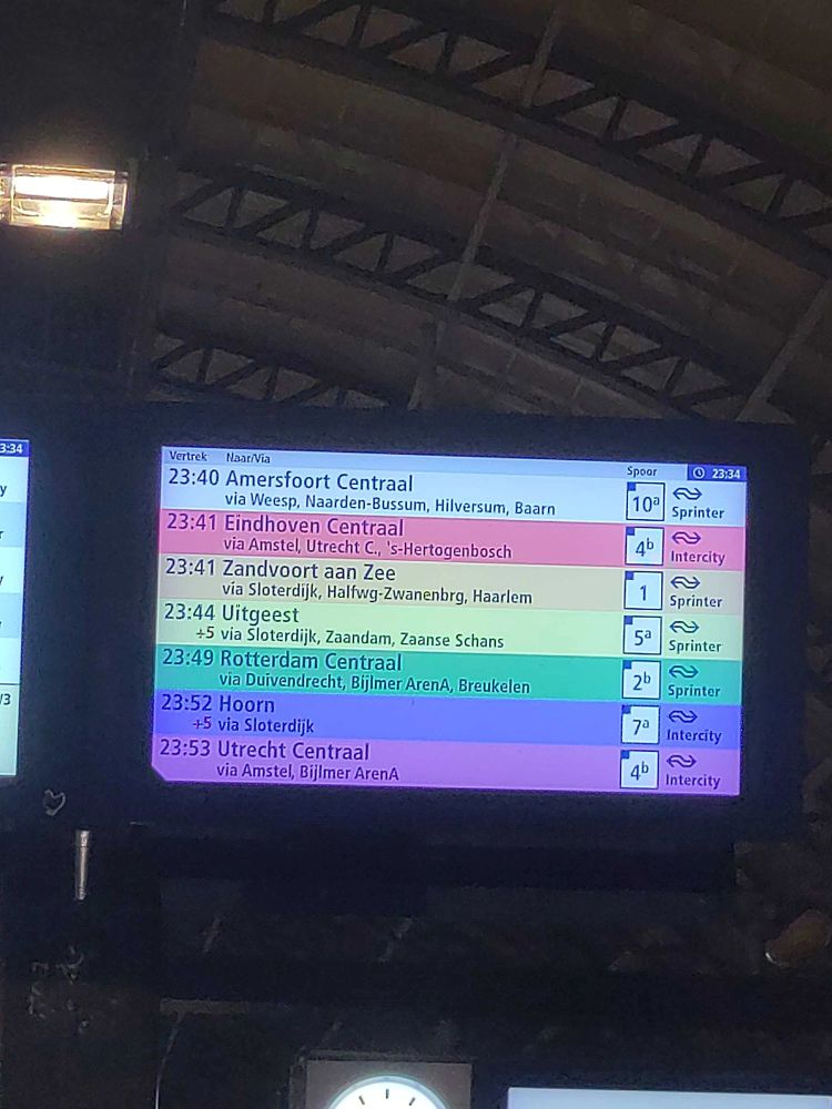 A train departure display using a rainbow as a background