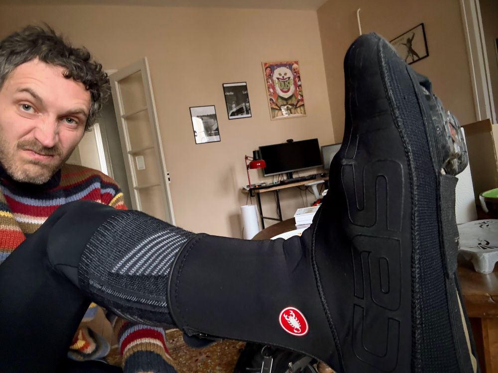 C’est moi et je montre mon pied arborant des sur-chaussures qui comme leur nom l’indique sont des petits appendices à poser par dessus les chaussures pour se protéger du froid à vélo