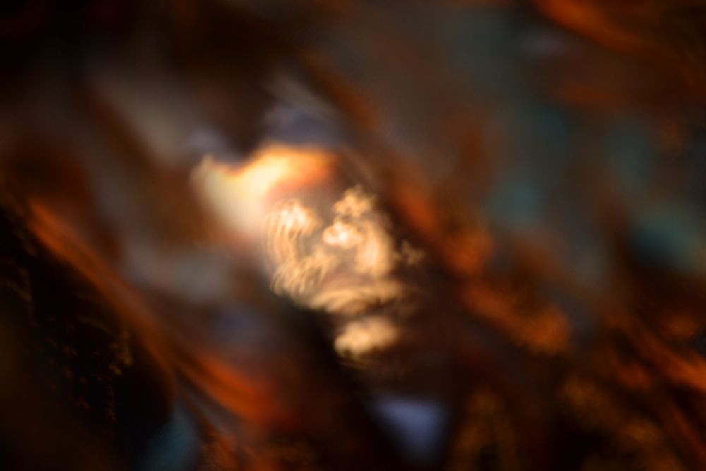 A little lion is moving quickly through a blurred maze of swirling orange and blue. He's got some important business to get to and he's determined to get there. This photo was taken by placing a small carved wooden lion (actually a very large bead, i think, i got him in a second hand craft store) on some burnout velvet fabric over some blue tulle. This is actually a composite of three photos in the same series, by combining parts of all three, I got to something l was happy with.