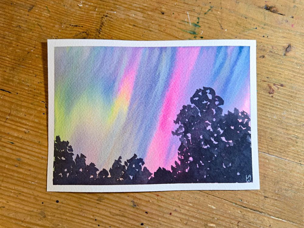 A watercolor painting of the Aurora Borealis, or northern lights. The sky is lit up with bright yellow-green and neon pink, with streaks of indigo for the night sky. There are silhouetted trees low in the foreground, with a couple of tall trees on the right side.