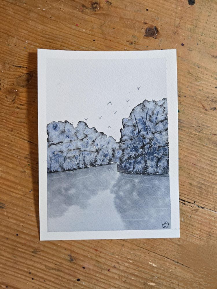 A monochromatic watercolor painting of snowy trees along a river,v with birds flying over the trees. Payne's Gray was used, along with salt on the trees to absorb some of the paint and create a snowy effect. 