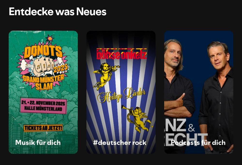 Screenshot aus der Spotify App
Drei Kacheln nebeneinander unter der Überschrift „Entdecke was Neues“.
Links: Konzertplakat der Band Donots für den „Grand Münster Slam 2025“ im November.
Mitte: Albumcover der Band Böhse Onkelz mit dem Titel „Heilige Lieder“, verziert mit goldenen Engeln.
Rechts: Foto von zwei Männern in schwarzen Hemden vor blauem Hintergrund. Unten steht „NZ & ECHT“, gemeint ist der Podcast Lanz & Precht.