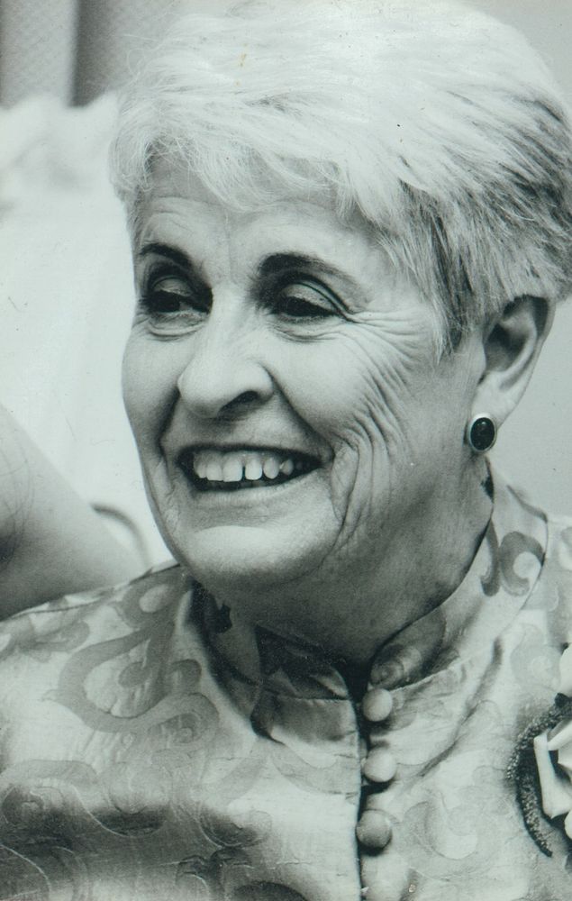 Black and white photo of a woman in her seventies smiling.