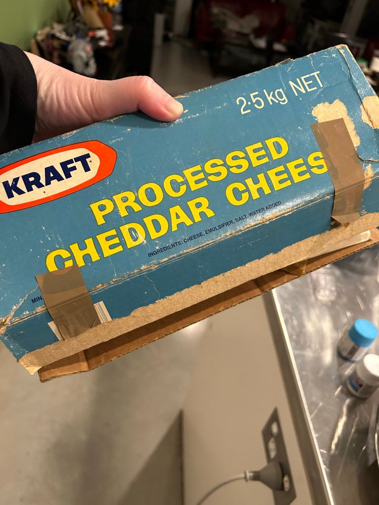 A very old box that says KRAFT PROCESSED CHEDDAR CHEESE on it