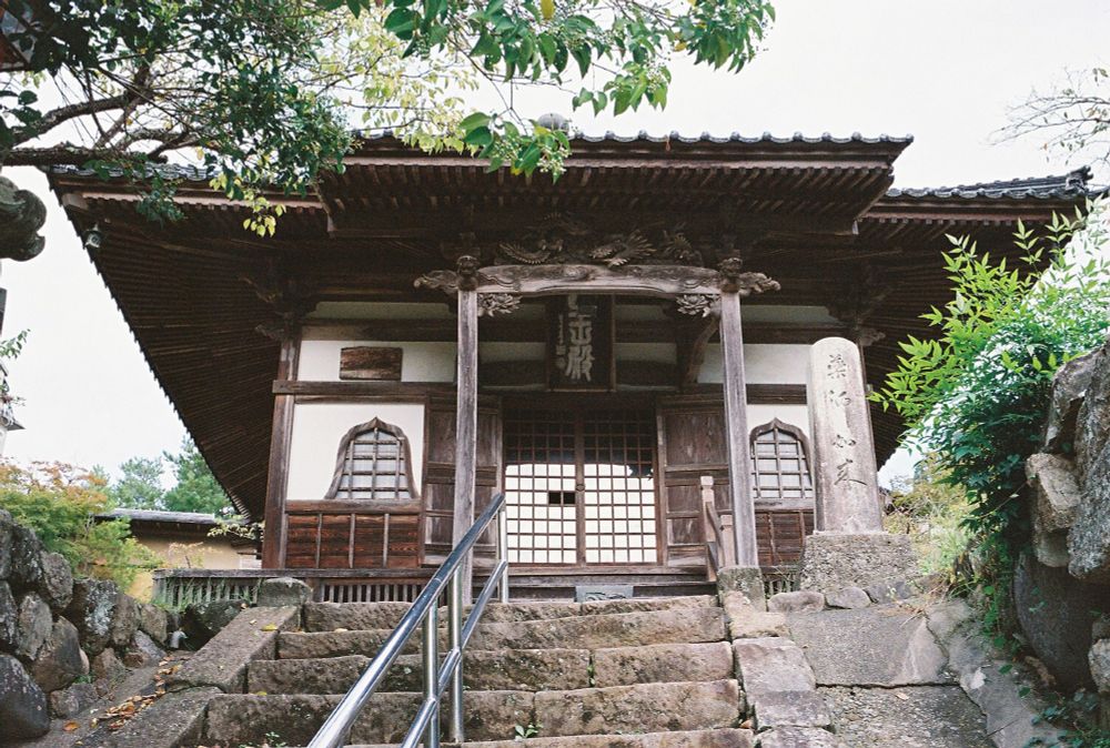 A buddhist temple in Yumura Onsen. Stone stairs with metal railing in the foreground.
