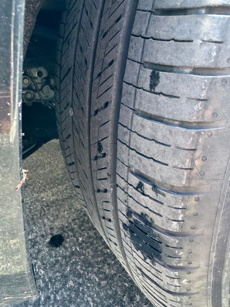 Picture of a car tire with a screw sticking out of it