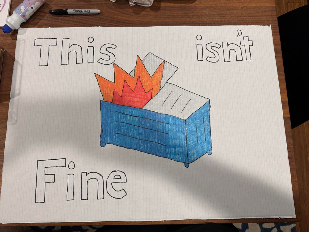 Hand drawn picture of a dumpster fire that says “this isn’t fine”. 