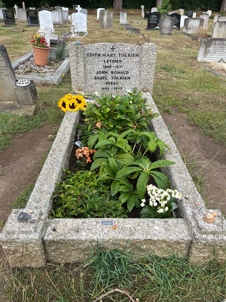 A stone grave with plants growing in the center. The headstone is for Edith Mary Tolkien and John Ronald Reuel Tolkien.