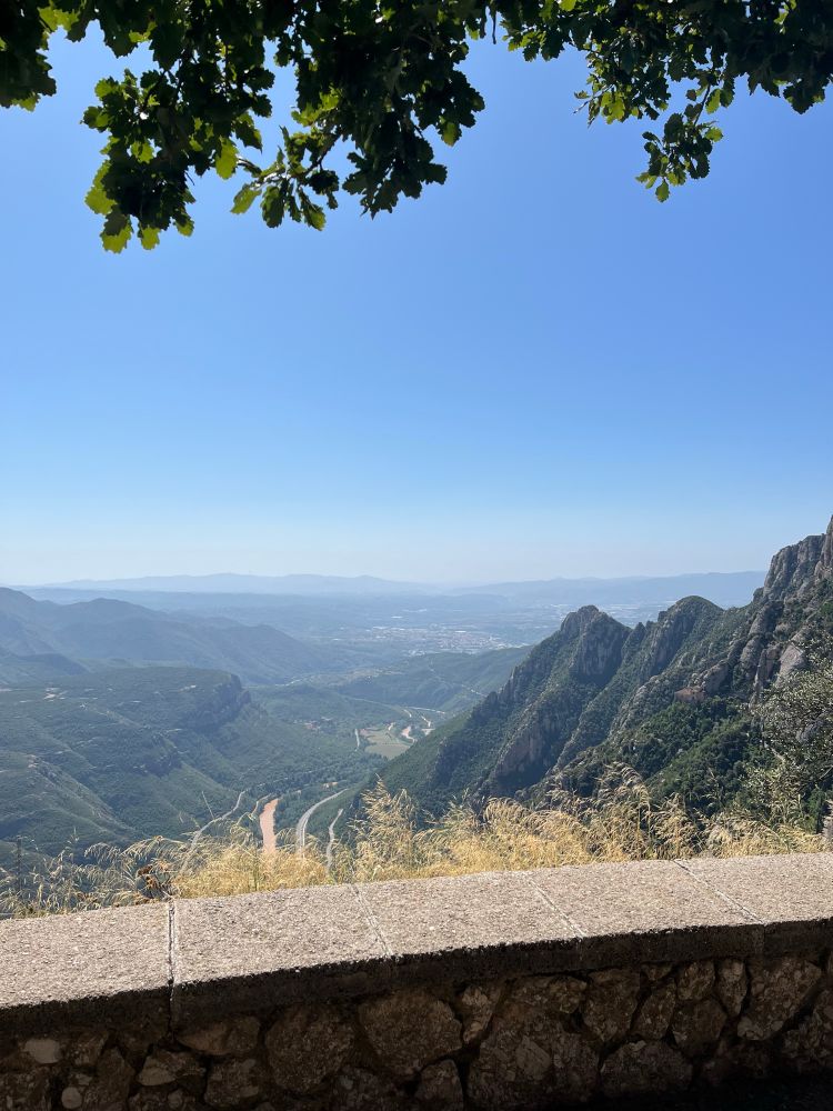 A view over looks green mountains and a distant valley.