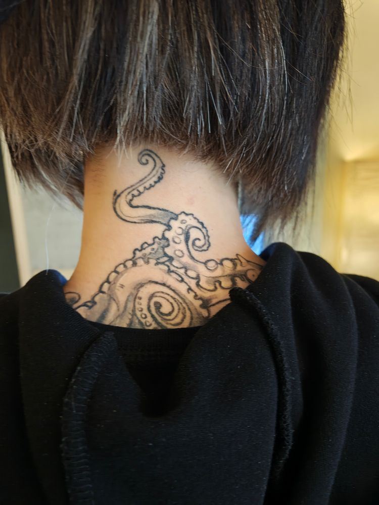 The back of my neck featuring tentacles tattooed coiling up the back