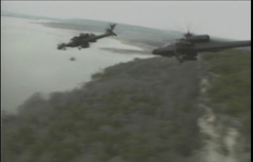 One of the FMV cutscenes that sporadically play using old footage of Apache gunships banking over a coastline forest