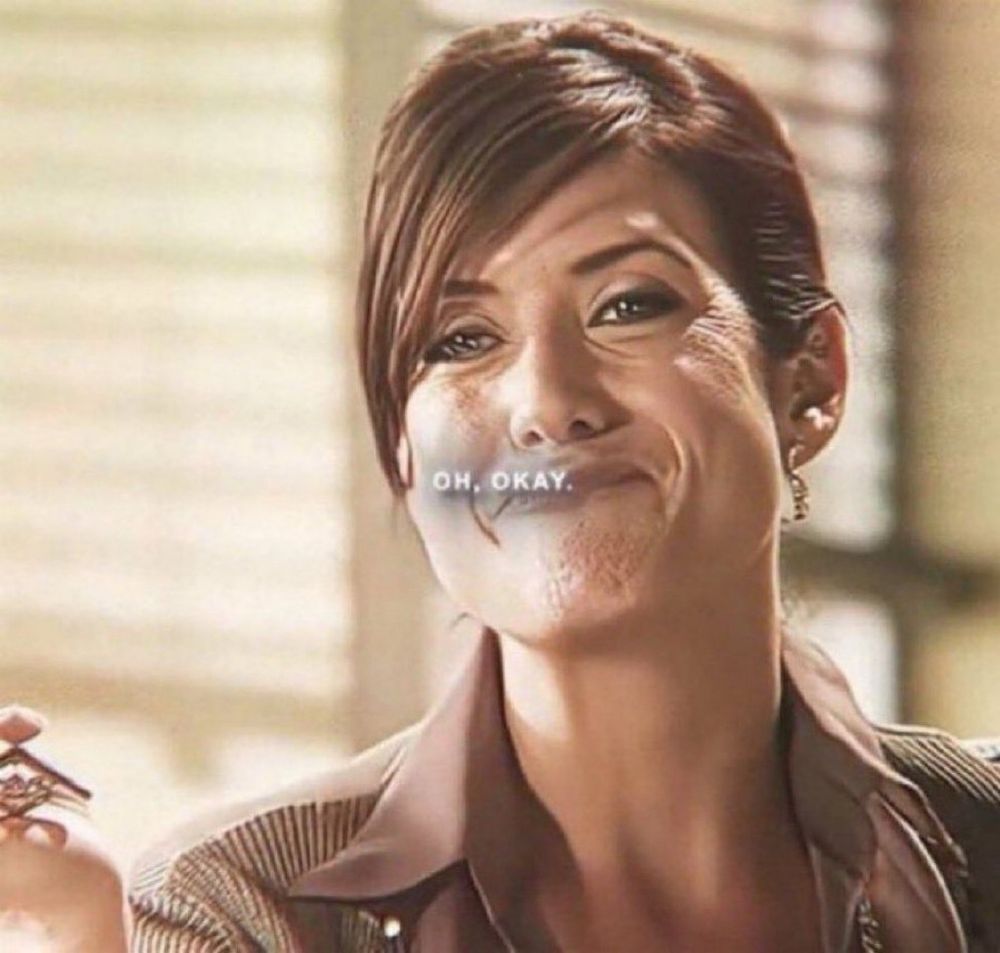 kate walsh in legion horror movie saying “oh, okay” with a quiet accepting smile on her face looking longingly at someone behind the camera and she’s wearing a tasteful brown collared shirt 