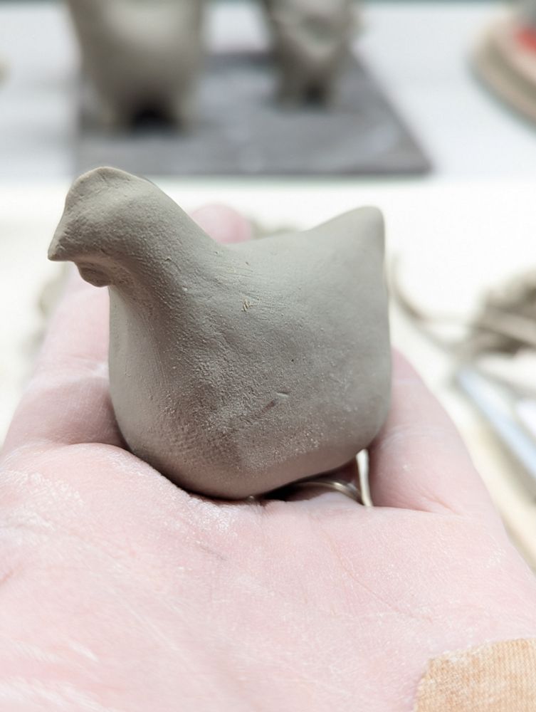 A clay chicken sits in a hand