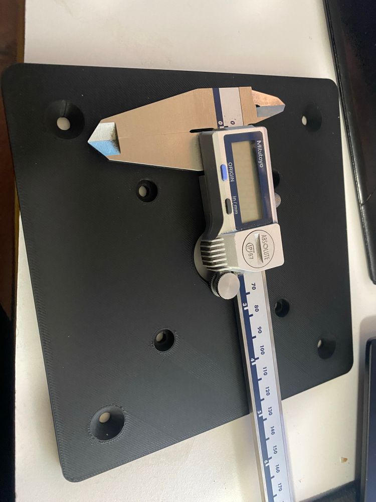 3D printed plate for to mount on a trim router’s fixed base with a pair of calipers 