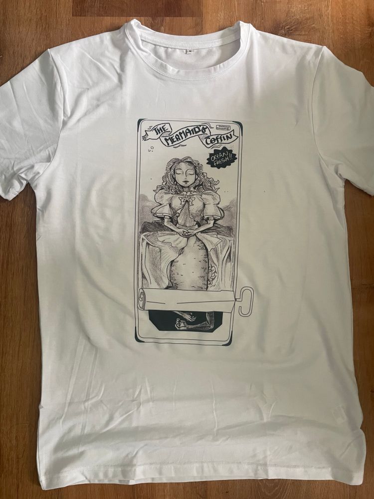 A white t shirt with a design of a sardine can on it. Instead of sardines, it advertises fresh mermaid. 