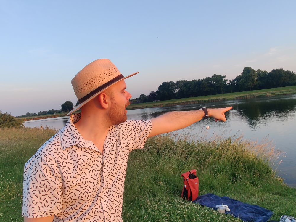 Same field place as the field photo, but with me pointing to the water with an amazed expression on my face.