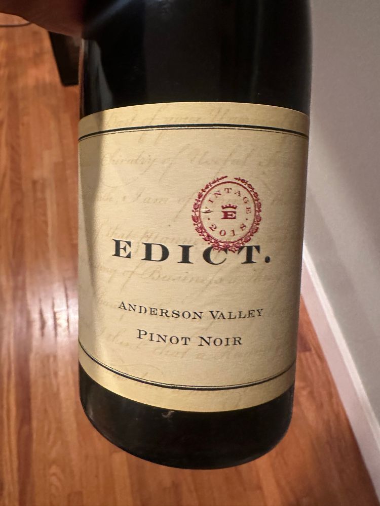 The front of a bottle of Edict Wine from Anderson Valley 

The label is a parchment-like color and feel. With a logo in red and the words EDICT. In capitals followed by Anderson Vally and Pinot Noir

Scanned:

“狗
01
EDICT.
ANDERSON VALLEY
PINOT NOIR”