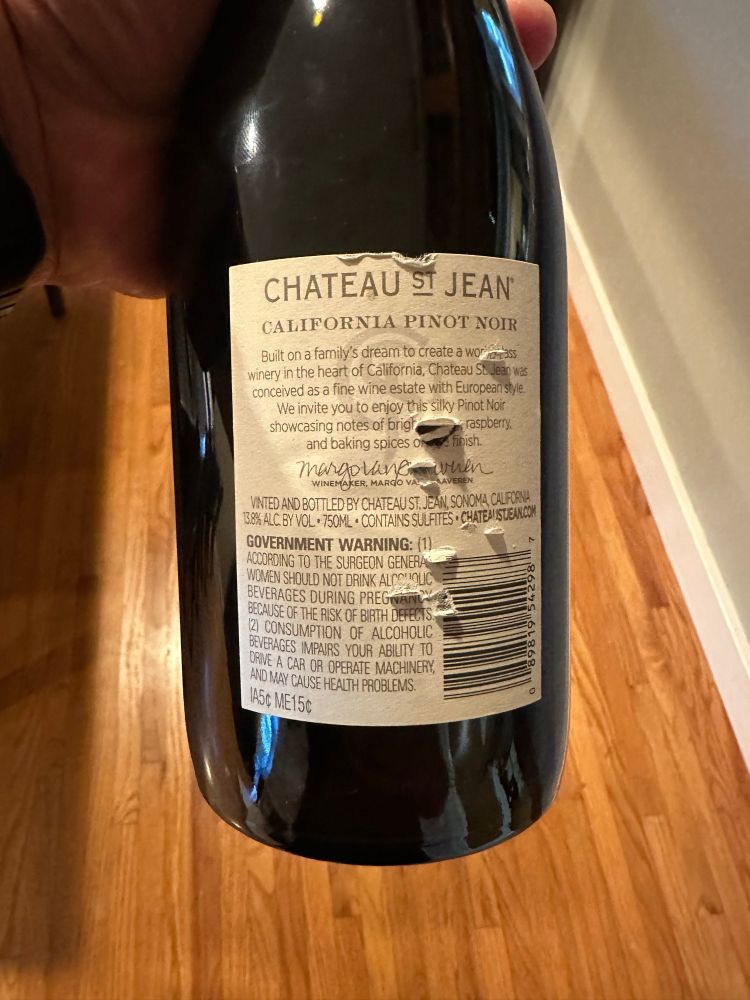 The back label of the bottle of wine:

Scanned:

“CHATEAU ST JEAN®
CALIFORNIA PINOT NOIR
Built on a family's dream to create a worraass winery in the heart of California, Chateau St Jean was conceived as a fine wine estate with European style.
We invite you to enjoy this silky Pinot Noir showcasing notes of brigh raspberry.
and baking spices o mbish.
margoven
WINEMAKER, MARd
LAVEREN
VINTED AND BOTTLED BY CHATEAU ST. JEAN, SONOMA, CALFORNA 138% ALC. BY VOL + 750ML • CONTAINS SULFITES • CHATEANISTUEANCON GOVERNMENT WARNING: (1)
ACCORDING TO THE SURGEON GENERA WOMEN SHOULD NOT DRINK ALTON QUEE BEVERAGES DURING PREGNANCY BECAUSE OF THE RISK OF BIRTH DEFECTS
(2) CONSUMPTION OF ALCOHOLIC BEVERAGES IMPAIRS YOUR ABILITY TO ORVE A CAR OR OPERATE MACHINERY, AND MAY CAUSE HEALTH PROBLEMS.
89819 54298
145¢ ME15c”