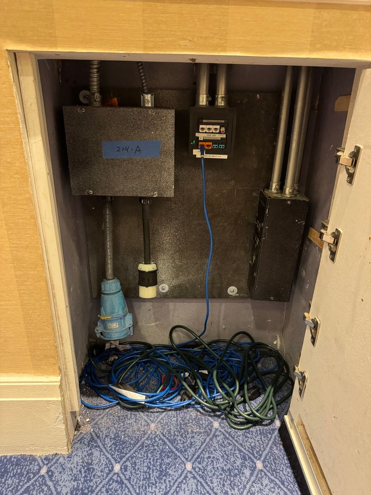 An opened wall cabinet showing a variety of AV and power receptacles