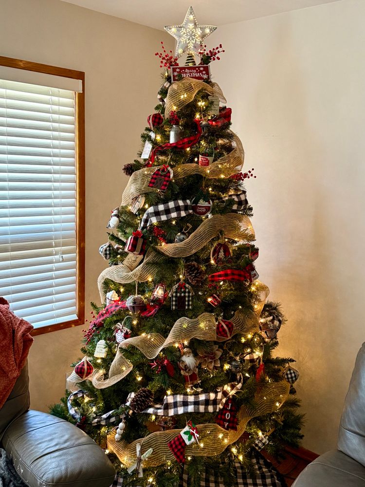 A country/rustic themed Christmas tree featuring burlap, red and black plaid, and white and black plaid. 
