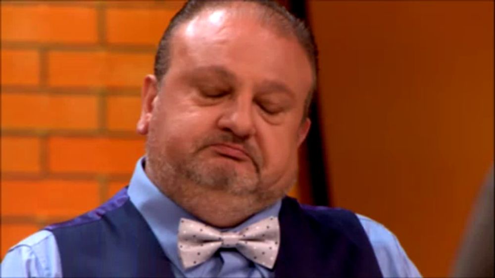 a man with a beard wearing a vest and bow tie