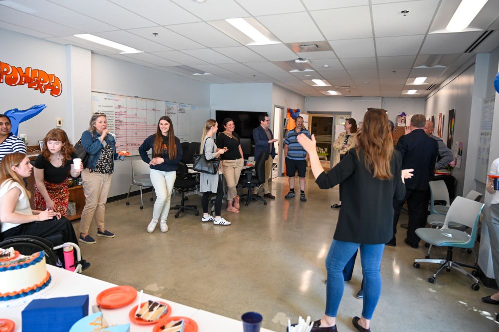 Another wide shot photo of people mingling at the party in CHASI's office space.