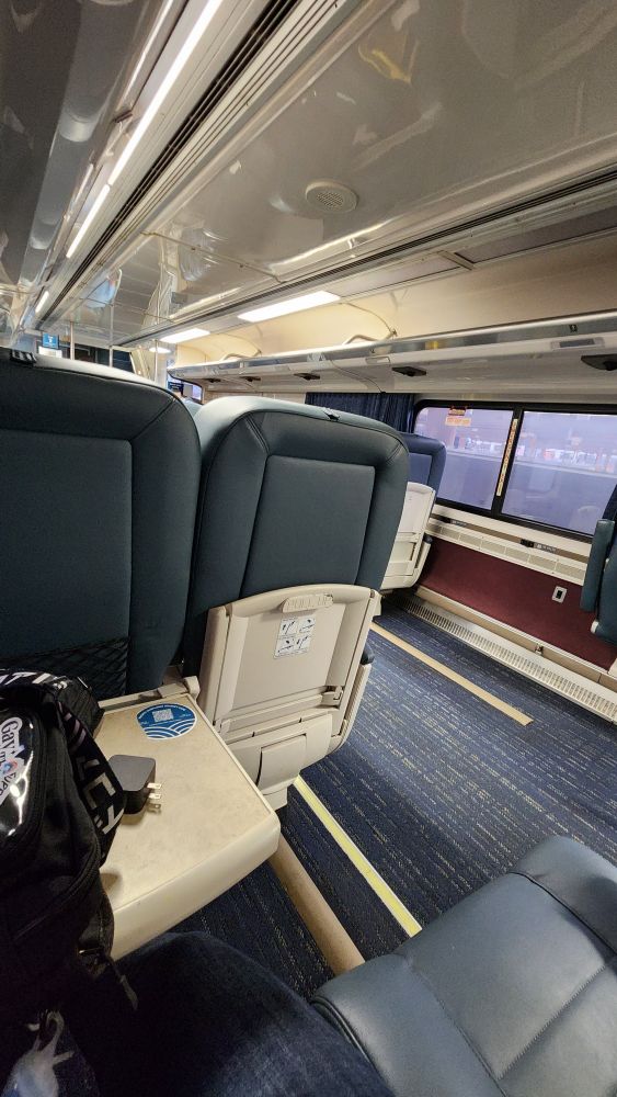 The interior seats of a spacious business class train car. 