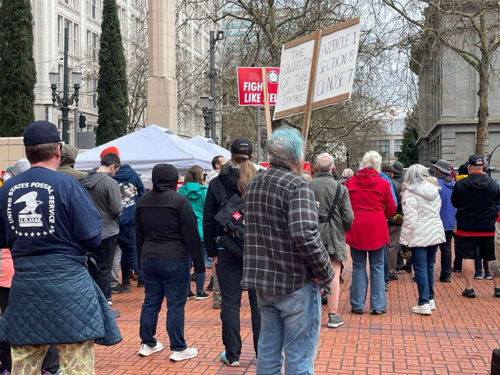 Fairly large group of people at the Portland Downtown Post Office carrying signs that says Save our Post Office and Fight Like Hell