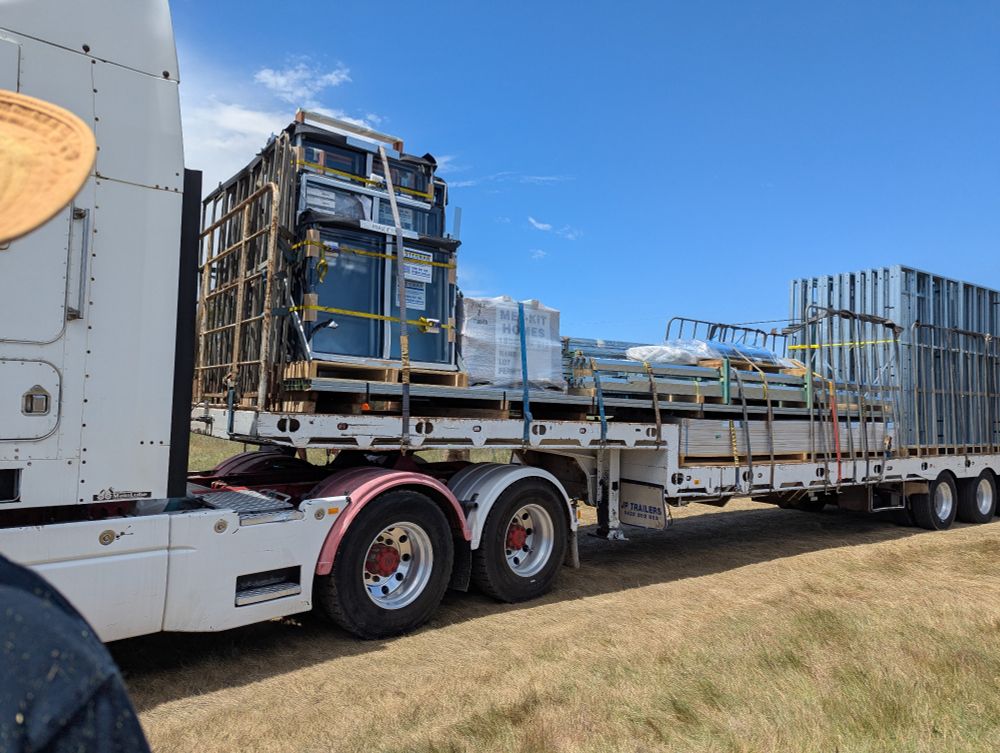 A large truck trailer containing pallets of windows, lots of steel framing, and other assorted bits and pieces I don't actually know the name of. 