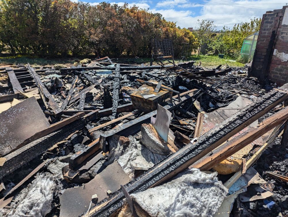 Burned rubble of a house. There's lots of beams and things. 