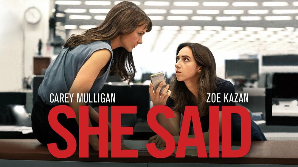 A promotional image for the movie "She Said" featuring actresses Carey Mulligan and Zoe Kazan in character in a newsroom talking to someone on speaker phone.
