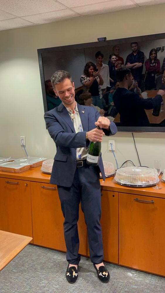Dr. Thrasher popping a bottle of champagne 
