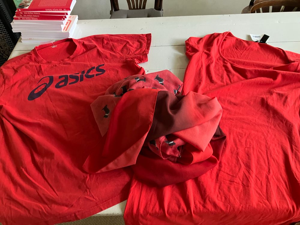 TShirts en Sjaals op hoop op tafel, allemaal rood voor protestdemonstratie elke donderdag 18 uur op een station bij jou in de buurt tegen genocide Gaza